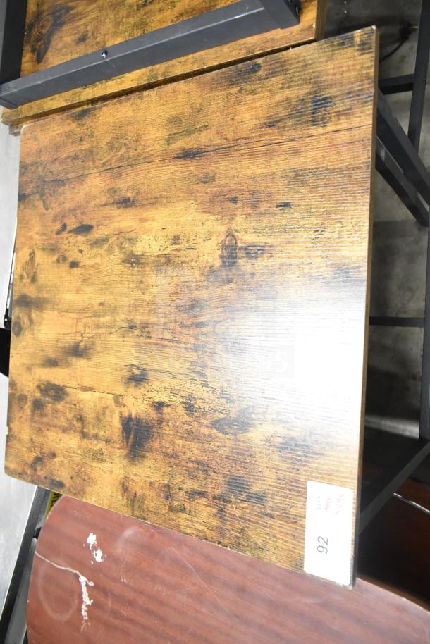 24 wood pattern tables with black metal frames, featuring bar height stools. Appears in good condition.