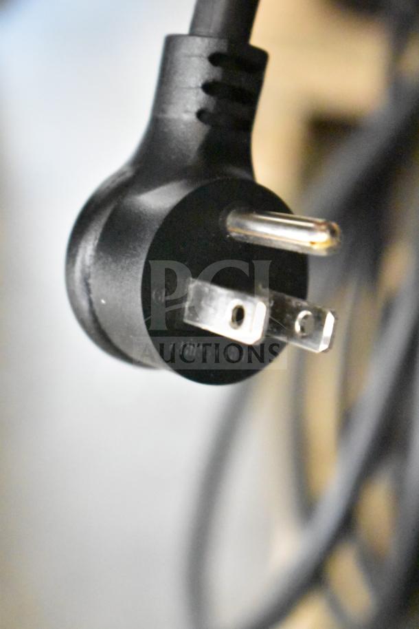 A close-up image of a power plug for a 2025 True GDM-47-HC-LD Cooler, 115 volts, 1 phase, showing three prongs.
