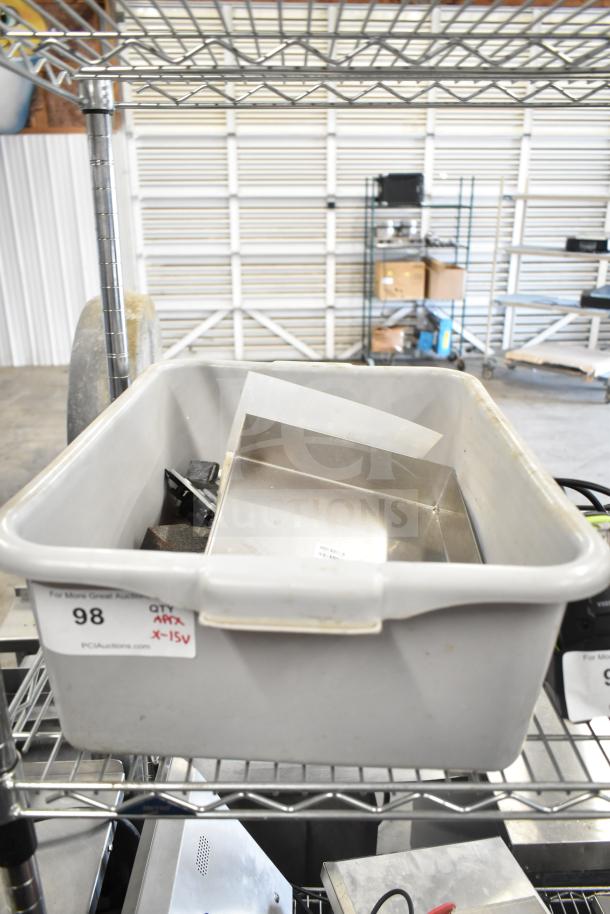 A collection of items including a gray poly bus bin, a metal bin, and a calculator on a wire shelf. Tags indicate "QTY" and item number 98.