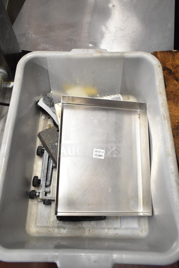 Lot of items including gray poly bus bin, metal bin, calculator, and assorted components. Some labels visible. Fair condition.