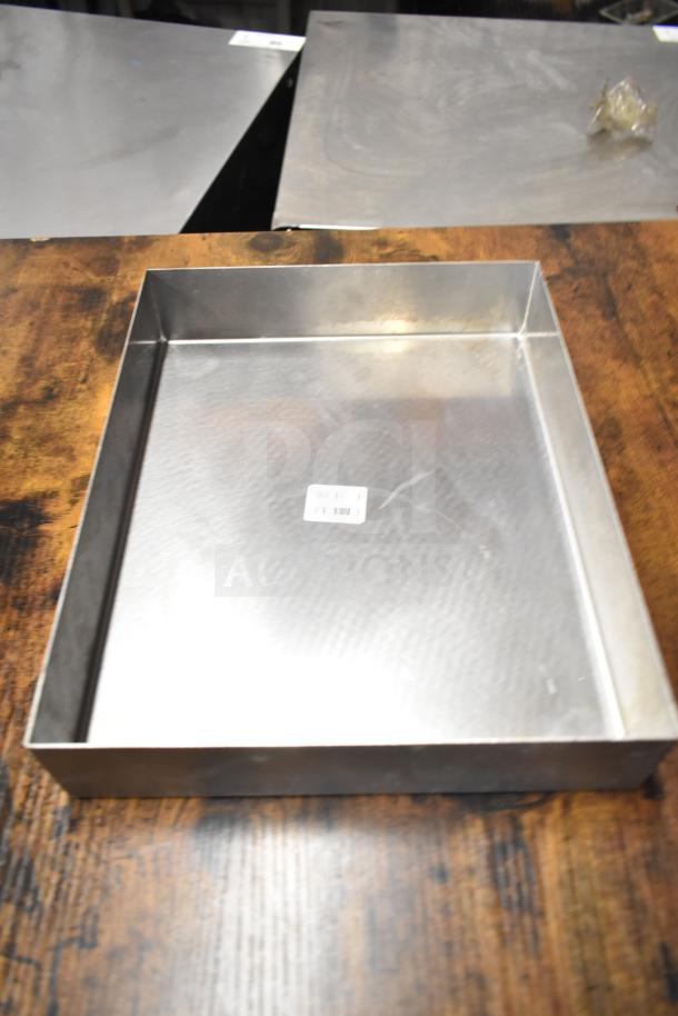 Stainless steel metal bin with a textured surface and barcoded label, part of a lot with various items.