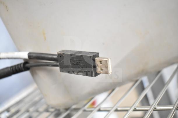 USB connector cable for Zebra DS3578 Barcode Scanner, slightly worn, shown on a metal rack.