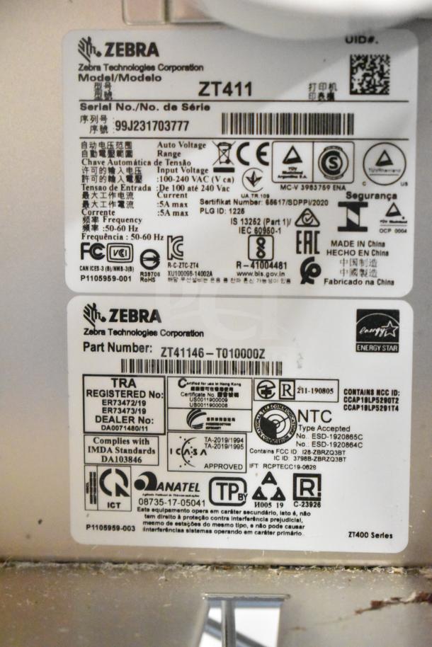 Zebra ZT411 Industrial Barcode Printer, model labels visible, serial number 99J23170377, compliance and certification details noted.