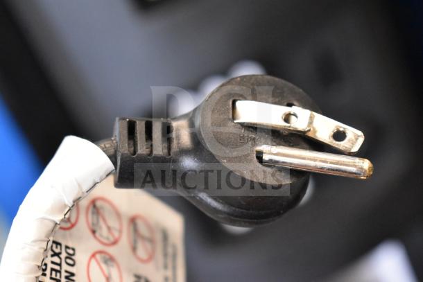 Power plug of Crane 5800-4 vending machine, showing electrical prongs and part of a warning tag.