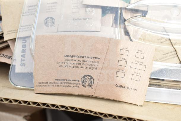 Stack of eco-friendly Starbucks hot cup sleeves. Made from 85% post-consumer fiber, new condition, includes customization options.