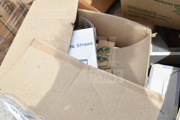 Box of assorted scratch and dent items, including Starbucks hot cup sleeves and plastic straws, in open packaging.