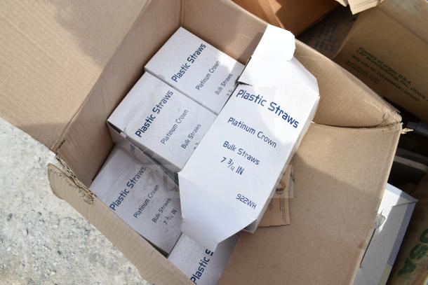 Boxes of Platinum Crown plastic straws in opened cardboard shipping box. Items are marked as brand new, part of a scratch and dent auction lot.