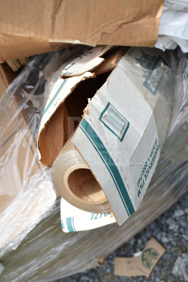 Cardboard box containing a roll of plastic film, labeled as "Foodservice Film," in damaged packaging.