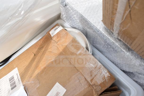Boxes with protective wrapping containing scratch and dent items, visible label reads "12x10 LATE." Assorted kitchen items inside.