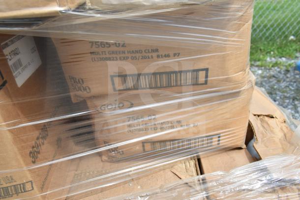 Plastic-wrapped stack of various cleaning product boxes, including Gojo Multi Green Hand Cleaner. Some boxes labeled with expiration date of May 2011. Scratch and dent condition.