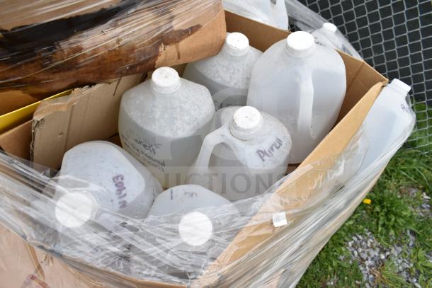 Cardboard box of gallon-sized cleaners and vinegar bottles, labeled “Purell,” sealed in plastic wrap, new scratch and dent condition.