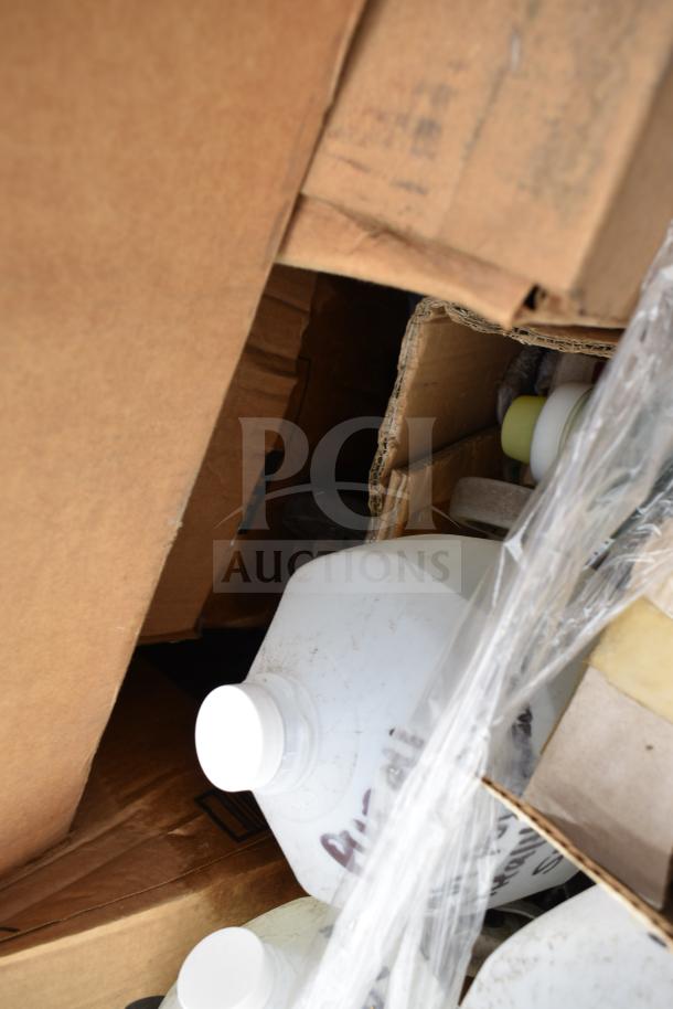 Cardboard boxes containing 25 new scratch and dent items, including cleaners and vinegar bottles, partially visible.