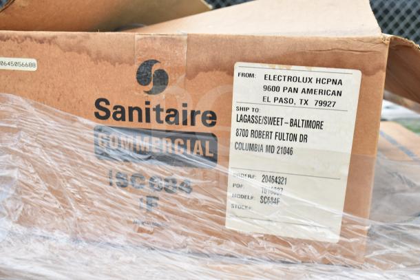 Cardboard box labeled "Sanitaire Commercial" and "Electrolux HCPNA." Contains assorted scratch and dent cleaning items.