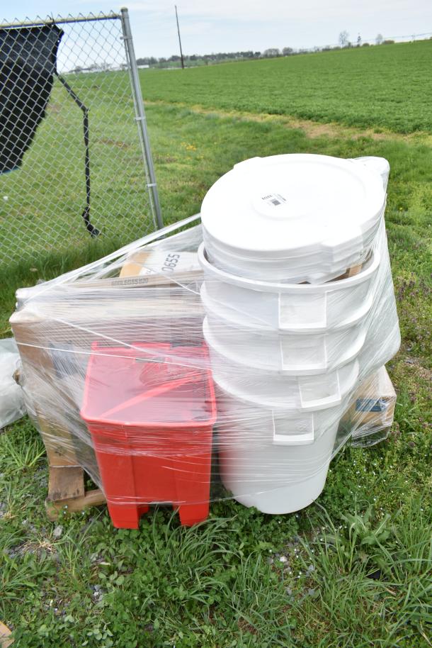 Palette of 16 scratch and dent items, including white trash cans and a red bin, all wrapped in plastic.
