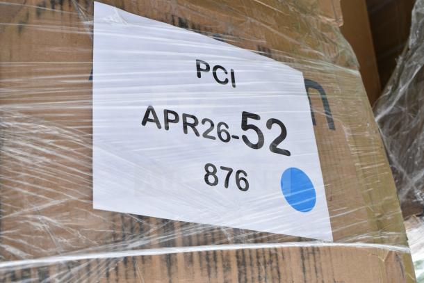 Cardboard package with label "APR26-52" and "876" under plastic wrap. Contains scratch and dent items, including a bakery display case and VitaMix blender.