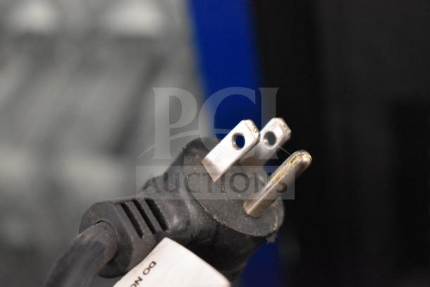 Close-up of a three-prong electrical plug attached to the Crane 5800-4 Commercial Bottled Drink Vending Machine.