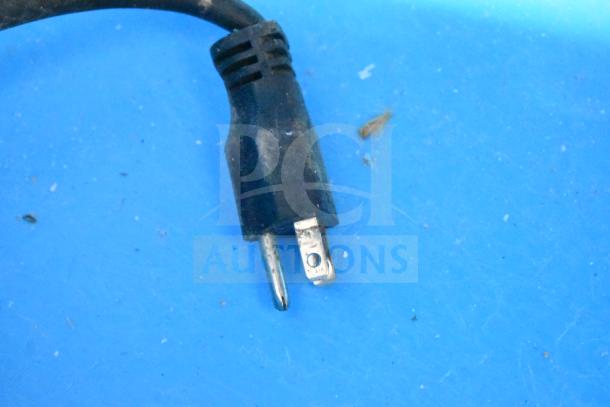 Close-up of a plug for the Manitowoc UYF0140A-161B Ice Machine, 115V, showing prongs and wire condition on a blue surface.