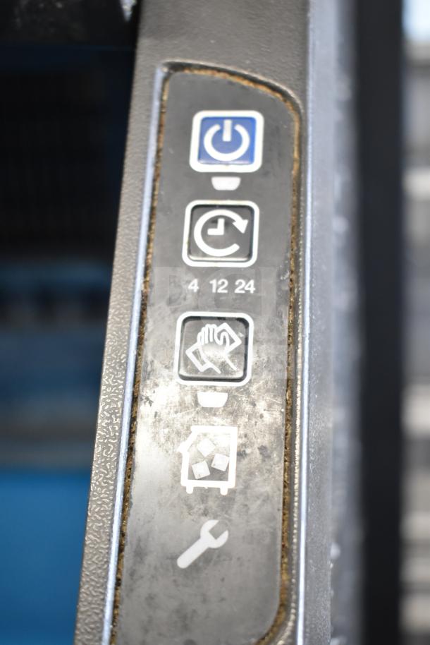 Close-up of control panel on Manitowoc UYF0140A-161B commercial ice machine, showing power and function icons.