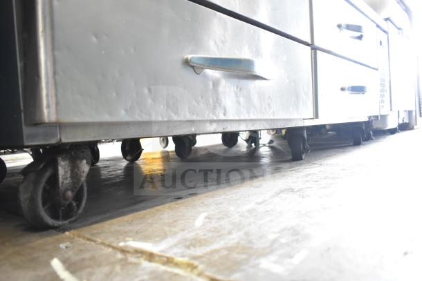 Commercial 4-drawer chef base with visible casters, stainless steel, 115 volts, 1 phase, used condition.