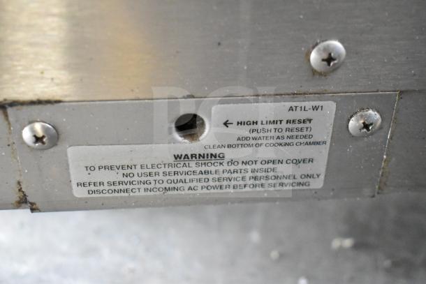 Commercial Electric Powered Single Compartment Steam N Hold Cabinet, 208/240 Volts, close-up of warning label and reset button.
