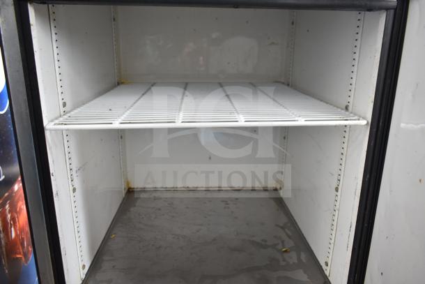 True T-23-2 commercial cooler interior with two shelves. Visible wear and rust in corners. On commercial casters, 115V.