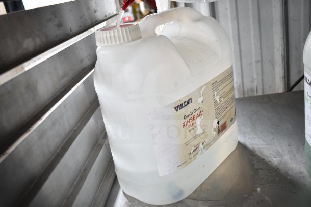 Large white container labeled "Vulcan Combi Oven Rinse Aid," with partially worn label, on metal surface.