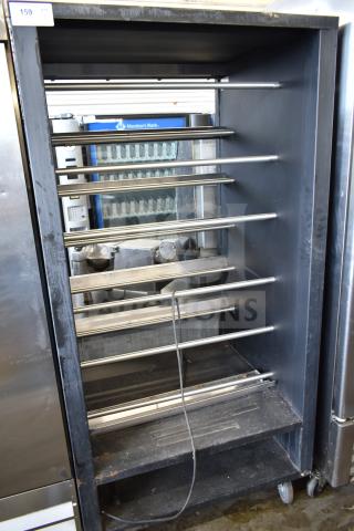 Vulcan 1013776 commercial pastry merchandiser on casters, steel racks, used, industrial design, visible wear.