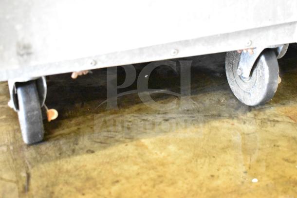 Lockwood commercial heated holding pan rack with durable commercial casters, shown with two black wheels, used condition.