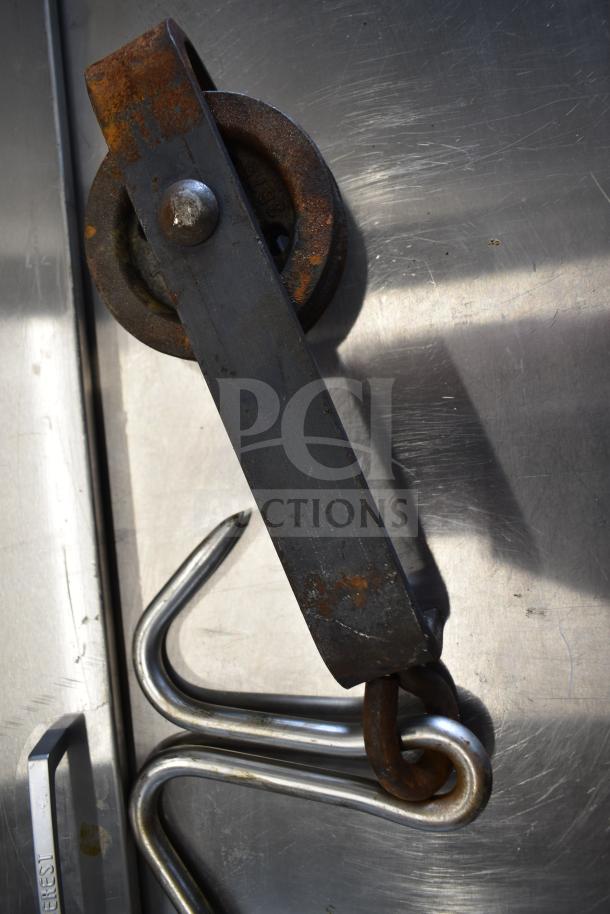 Rusted trolley roller with metal bracket and hook, scratches visible on metal surface. Auction item: 11 rollers.