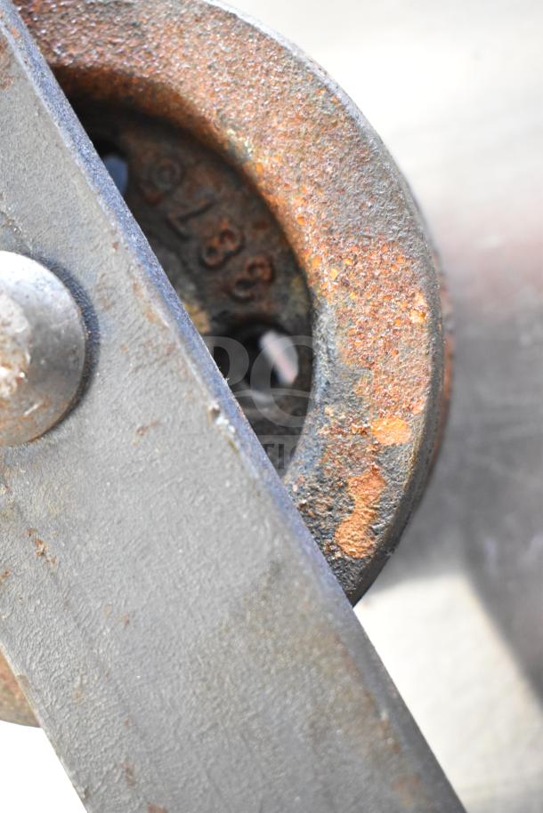 Rusty metal trolley roller, showing detailed texture. Marking "928" visible. Auction includes 11 rollers, one bid.