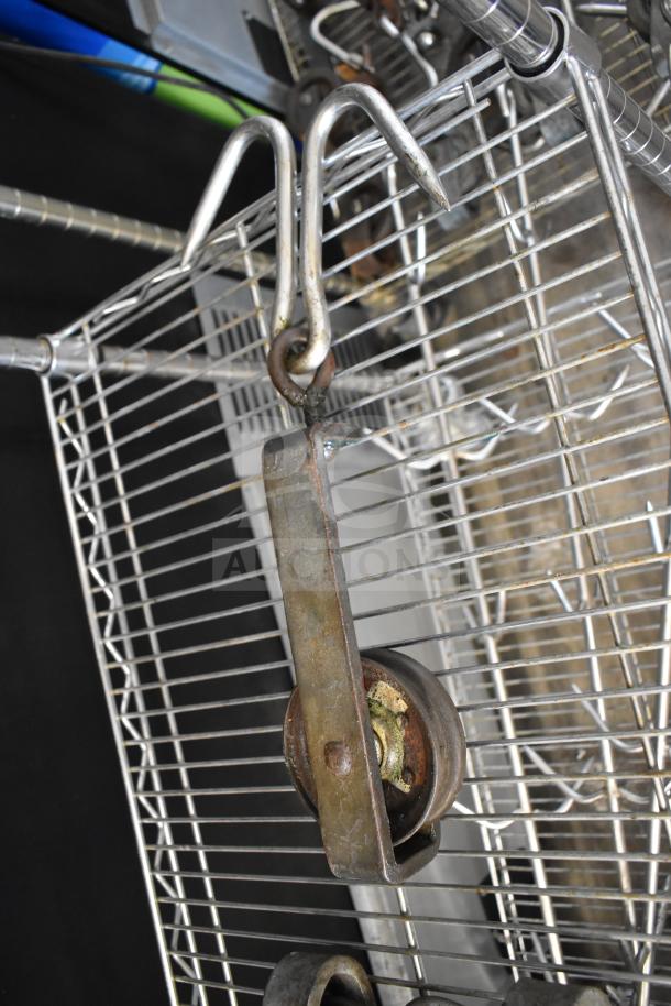 Five metal trolley rollers displayed, featuring a hooked design. Condition shows signs of wear, ideal for heavy-duty use.