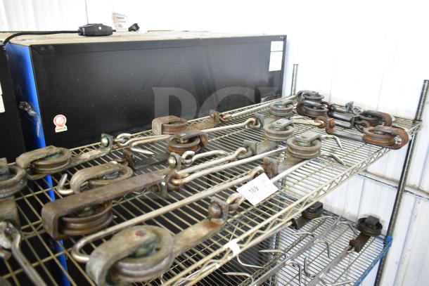 15 industrial trolley rollers on metal shelving, used, various conditions. Auction tag reading "169" visible.