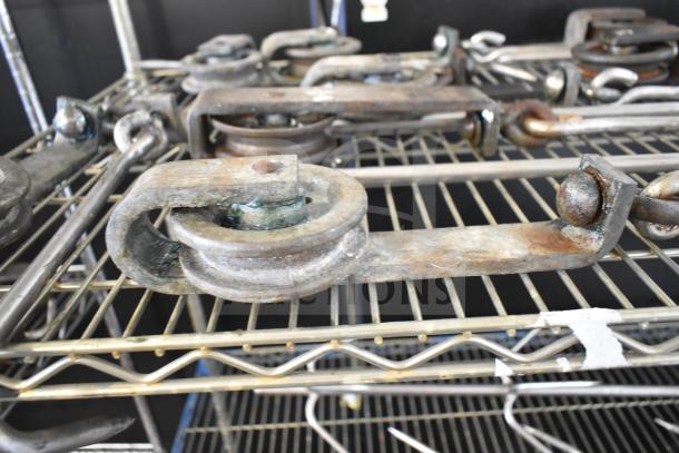 15 trolley rollers in used condition on a metal shelf, featuring metal construction with visible wear and rust.