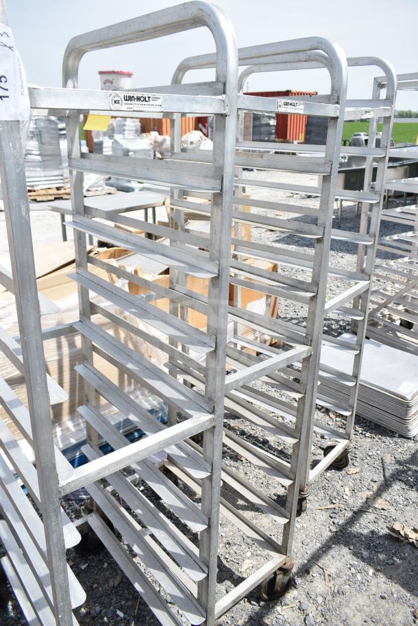 Three commercial pan transport racks on sturdy casters by Win-Holt, used condition, suitable for bakery or kitchen use.