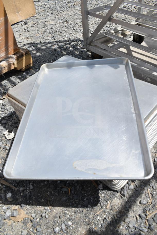 Set of 23 full-size aluminum baking pans, used condition, each with a raised edge. Ideal for commercial use.