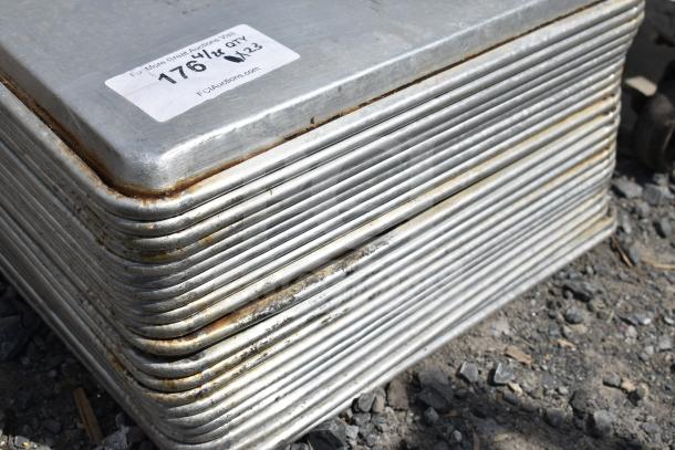 Stack of 23 full-size baking pans showing wear, each pan with rounded corners. Auction tag indicates lot 176, quantity 23.