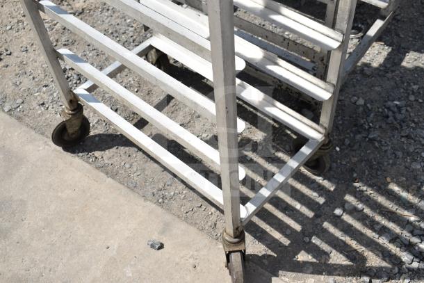 Commercial pan transport rack with multiple shelves and durable casters. Sturdy metal frame, good condition.