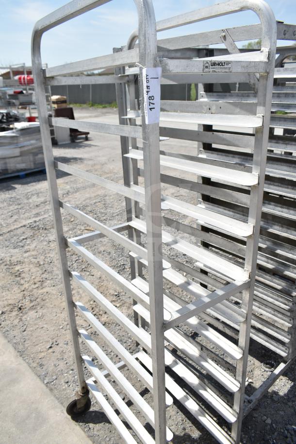 Commercial pan transport rack with multiple shelves on sturdy casters, label reads "Winholt." Used, good condition.