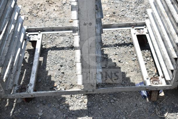 Commercial double pan transport rack with visible wear, featuring durable commercial casters for mobility.