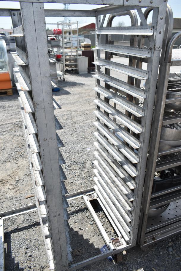 Commercial double pan transport rack with metal frame on sturdy commercial casters. Good condition, outdoors.