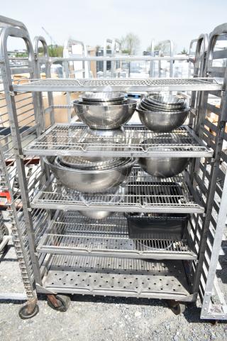 Commercial transport rack on casters with metal wire shelves, containing stacked metal bowls. Good condition.