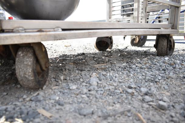 Commercial transport rack with sturdy casters, includes metal bowls. Suitable for heavy-duty use. Dirt on ground visible.