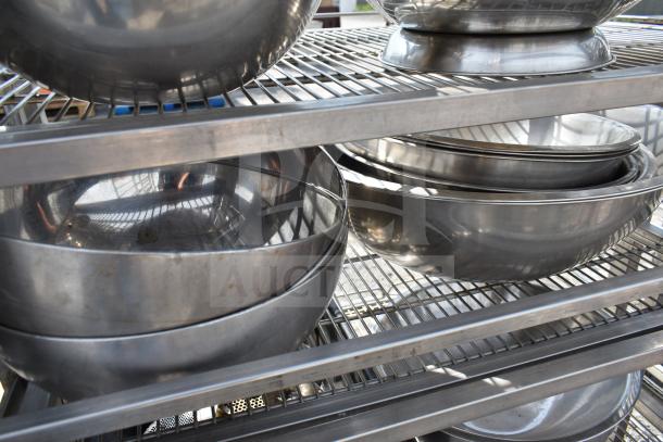 Commercial transport rack with metal bowls on shelves, mounted on commercial casters. Clean and sturdy for industrial use.