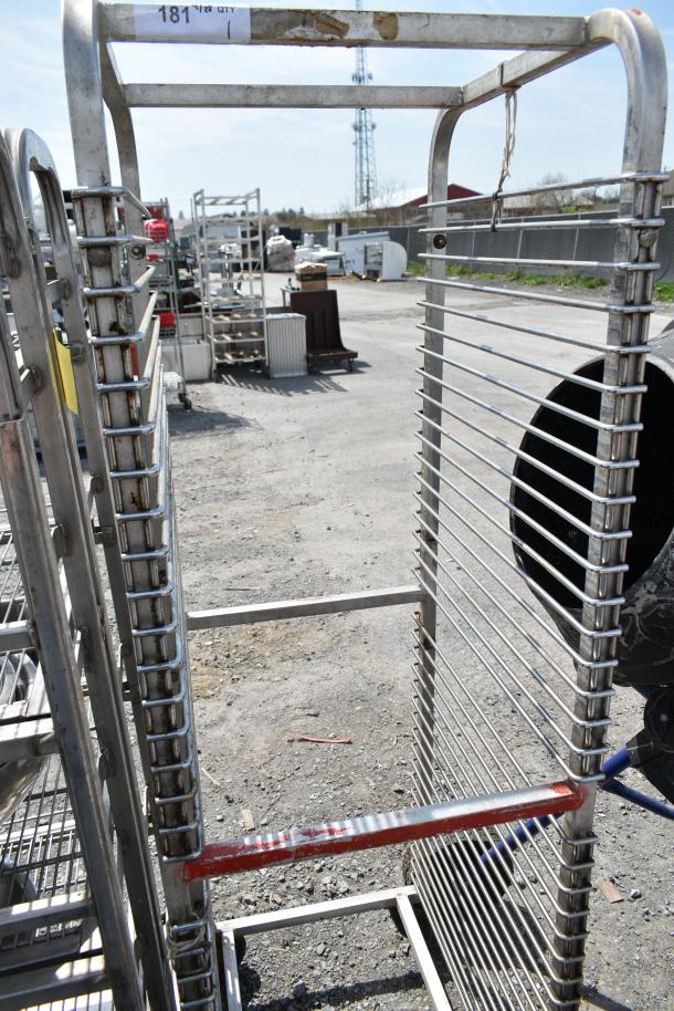 Commercial pan transport rack on casters, metal frame, multi-shelf design, outdoor setting, visible wear, tag marked "181".