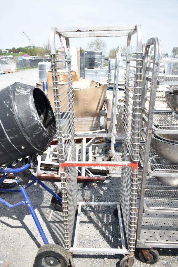 Commercial pan transport rack with metal shelves and durable casters, designed for easy mobility. Visible wear suggests used condition.