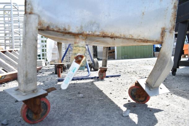 Commercial portable bin on sturdy casters, shows wear with rust visible, suitable for industrial storage needs.