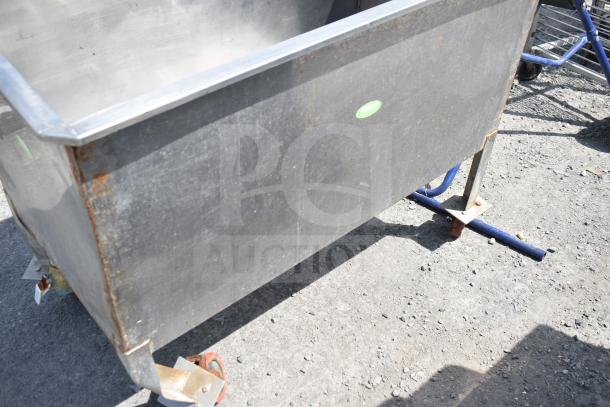 Commercial portable bin on casters, metal structure, used condition with rust marks, label indicates "BARG."
