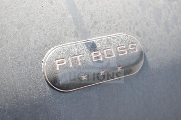 Pit Boss PB1500NX Savannah Pellet Grill, featuring a prominent brand emblem. Noticeable dust, suggesting outdoor use.