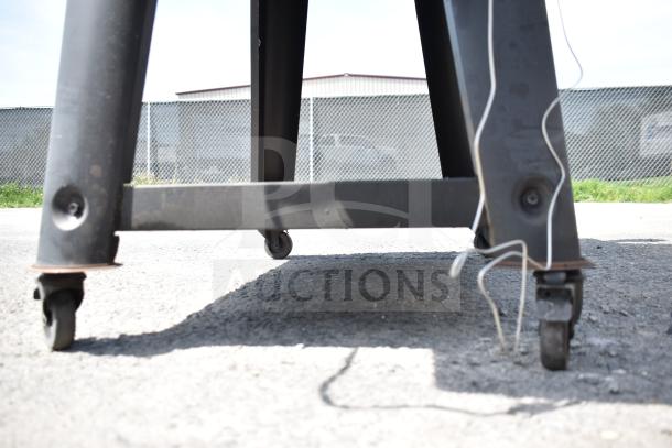 Pit Boss PB1500NX Savannah Pellet Grill featuring commercial casters, shown from a low angle outside on pavement.