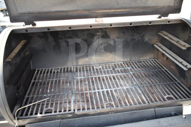 Pit Boss PB1500NX Savannah Pellet Grill, showing interior cooking grates. Used condition, on commercial casters.